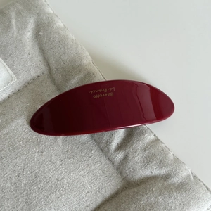 Dettaglio della molletta in acetato rosso vino con scritta dorata Barrette La France