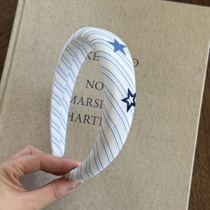Detail of blue striped fabric headband with star embroidery on a vintage book