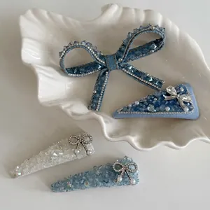 Blue denim crystal bow hair clips and rhinestone hairpins set in a shell tray