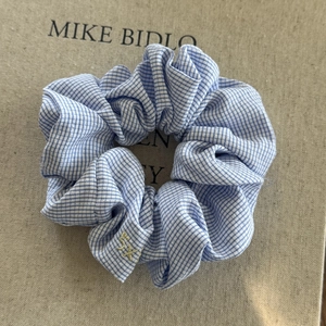 Close-up of blue striped fabric scrunchie on beige textured book background