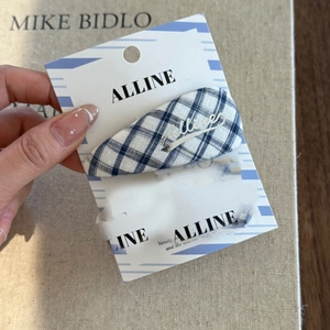 Close-up of blue and white checkered fabric hair clip on branded card display