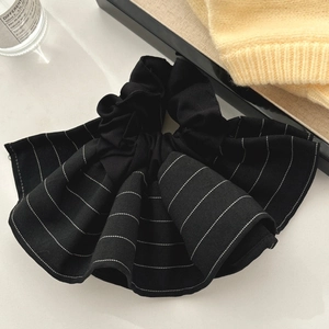Close-up of black and white striped ruffled hair scrunchie with a layered skirt-like design