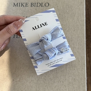 Close-up of blue striped and plaid bow hair clips set on a stylish brand display card