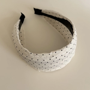 Close-up of cream polka dot pleated chiffon headband with black non-slip lining