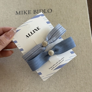 Detail view of light and medium blue striped bow hair clips set with metallic mesh ornaments