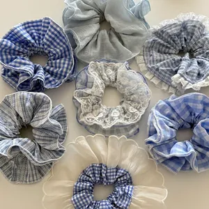 Set aus sieben blau-weißen Spitzen-Karo-Haargummis auf sauberem weißem Hintergrund