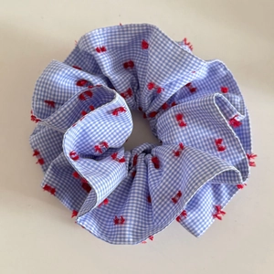 Blau-weißes Gingham-Haargummi mit roten Pompons für elegante Dutt-Frisuren