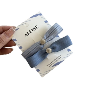 Blue striped bow hair clips and scrunchies set on branding card in hand