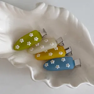 Set di quattro fermagli per capelli a fiori di frangipani in una ciotola decorativa