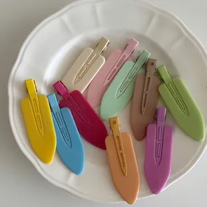Set of 10 matte colorful duckbill hair clips in pastel tones displayed on a white plate