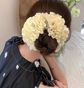 Detailed view of beige polka dot scrunchie styled on a classic bun hairstyle