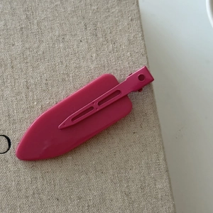 Matte rose pink large duckbill hair clip on textured beige canvas for hairstyling