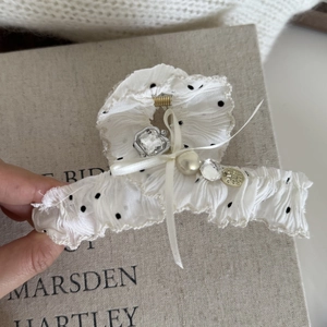 Détail de la pince à cheveux en dentelle à pois bleus et blancs avec perles et cristaux