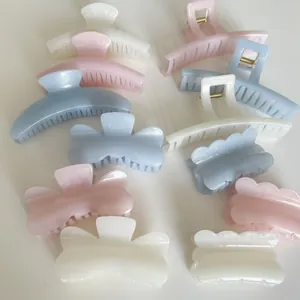 Flat lay of pastel hair claw clips in jelly blue, pink and pearl white colors