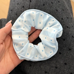 Detaillierte Textur des blau gestreiften Spitzen-Scrunchies mit Punkten für Frisuren