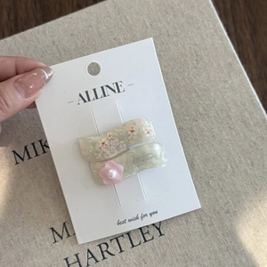 Detail of pink floral hair clips with 3D flower and pearl on a white cardboard