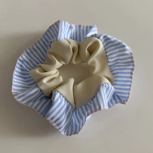 Detail of blue striped scrunchie with layered cream fabric and pink wavy edges