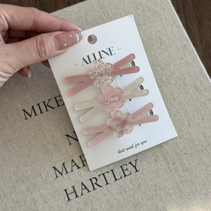 Detailed macro of 3-piece floral hair clips in pink and cream with matte finish