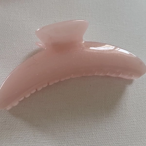 Close-up of pink translucent glitter hair claw clip with smooth acrylic texture