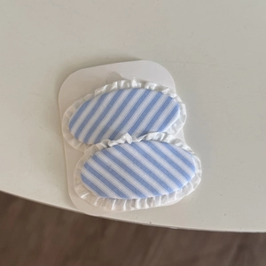 Blue and white striped hair clips set with elegant white lace trim on display card