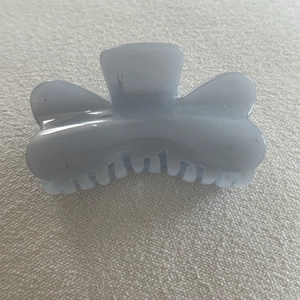 Detailed top view of a glittery blue translucent hair claw clip on white fabric