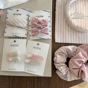 Pink striped hair accessories set with bow clips, scrunchies, and a headband