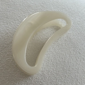 Detailed view of milky white jelly texture and sleek semi-circle design on hair claw clip