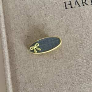 Macro detail of denim fabric hair clip with yellow trim and small bow decoration