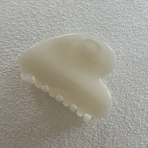 Close-up of heart-shaped cream jelly hair claw clip with smooth resin texture