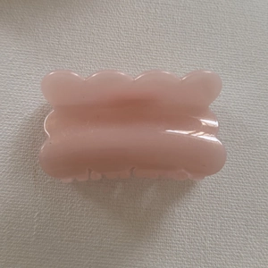 Detail view of pink glitter jelly hair claw clip with scalloped edges and wavy resin texture
