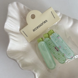 Set di 3 fermagli per capelli a fiori e righe su un piatto decorativo a forma di conchiglia