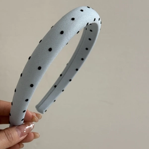 Detailed shot of light blue ribbed headband with black flocked polka dots and wide frame