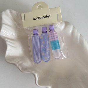 Set di tre fermagli per capelli a fiori e quadri su un vassoio a conchiglia bianca