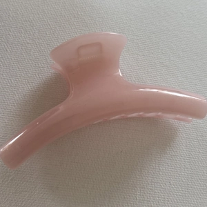 Detailed view of the light pink jelly hair claw clip with its durable metal spring mechanism