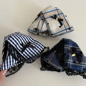 Detail of nautical plaid hair claw clip featuring black lace trim and satin bow pendant