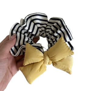Stylish yellow bow scrunchie with black and white striped pleated fabric hair tie