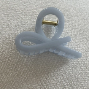 Detailed view of light blue hair claw clip with glossy finish and strong gold metal spring