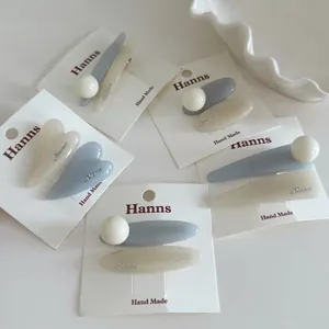 Sweet blue and cream hair clip set with hearts and ovals on a white display card