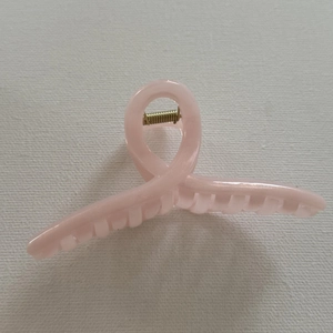 Top-down view of pink jelly hair claw clip with glossy resin finish and gold spring