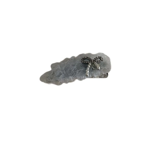 Barrette en dentelle grise avec nœud en perles et strass sur fond blanc épuré