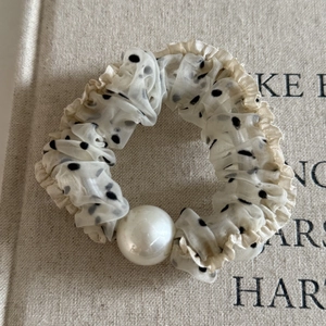 Detail of French polka dot mesh scrunchie with lace edges and a large faux pearl bead