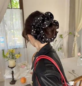 Polka dot satin scrunchie shown in a stylish hair bun hairstyle for women