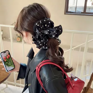 Oversized satin polka dot scrunchie with ruffled edges shown on a ponytail hairstyle