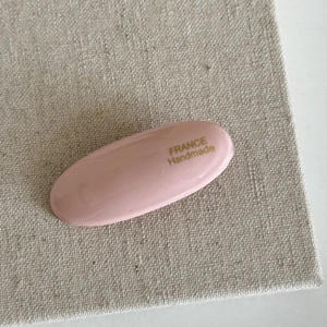 Nahaufnahme der rosa ovalen Haarklammer aus Harz mit goldener France Handmade Aufschrift
