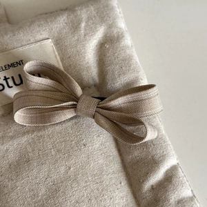 Nahaufnahme der beigen Stoff-Haarspange mit Schleife und feiner Textur für Damen