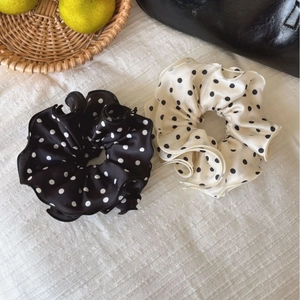 Pair of elegant satin polka dot hair scrunchies in black and white with ruffled edges