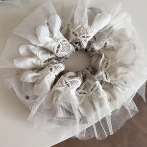 Detailed close-up of double-layer lace scrunchie with polka dots and embroidery