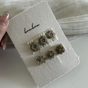 Detailed macro view of hand-stitched floral embroidery on brown lace hair clips