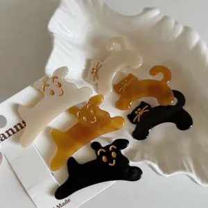 Detailed view of cute acetate dog and cat hair clips in cream, amber, and black colors
