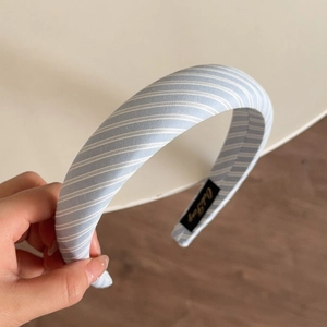 Close-up of light blue striped sponge headband with soft fabric texture and inner tag